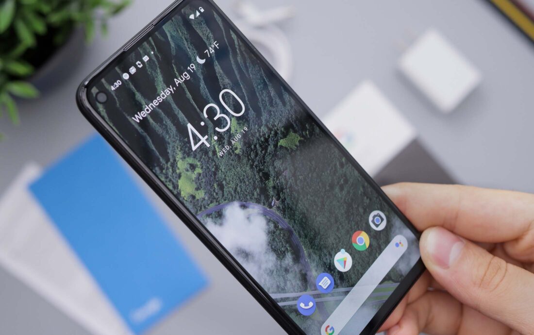 Titelbild- Handy mit grünem Hintergrund in Hand